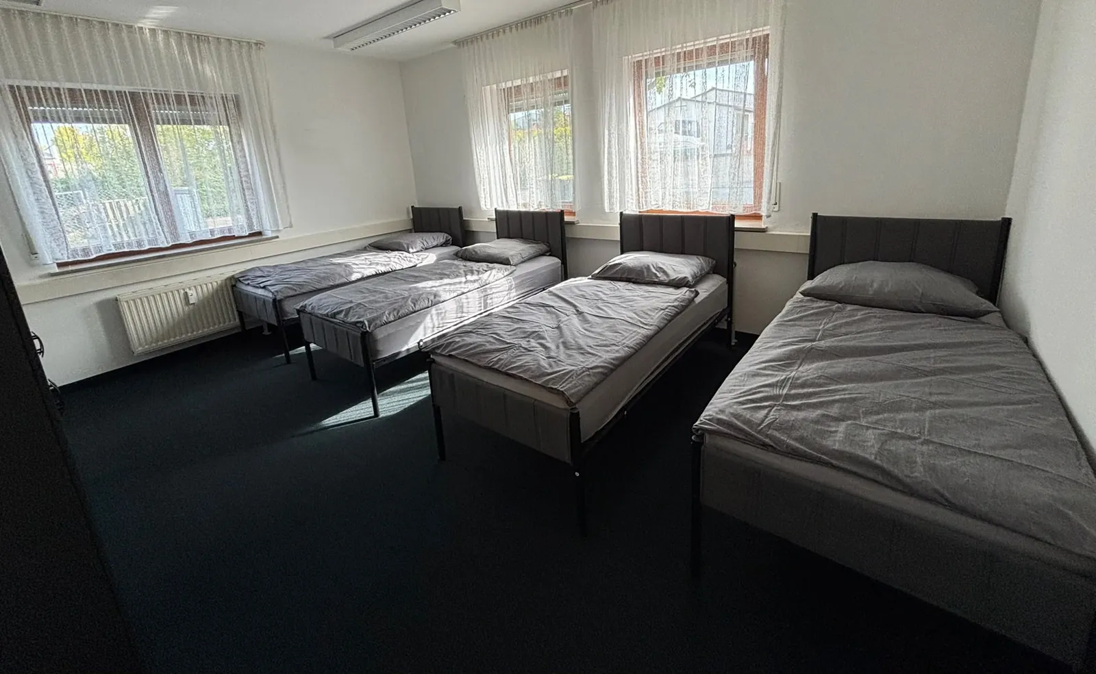 Zimmer der Kola Pension mit mehreren Einzelbetten